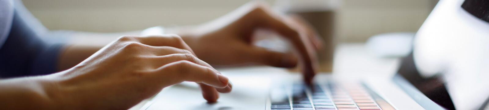 Hands typing on a laptop