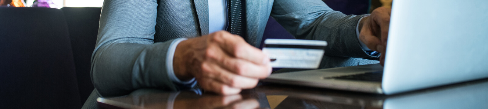 Man using a credit/debit card at laptop